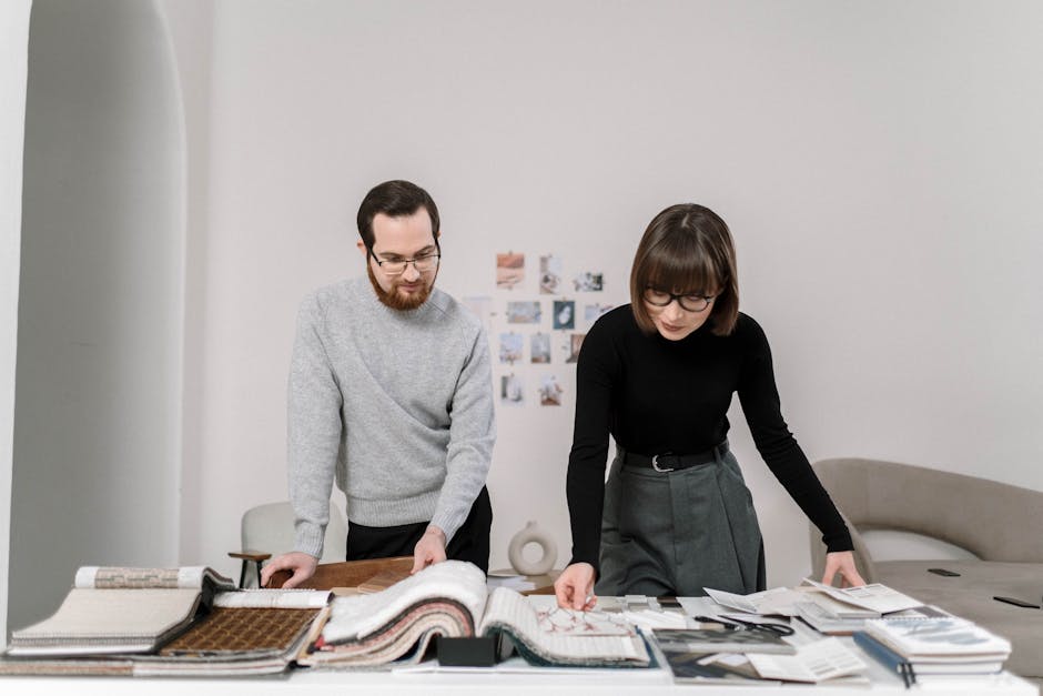 A man and woman reviewing fabric swatches, engaged in an interior design project.